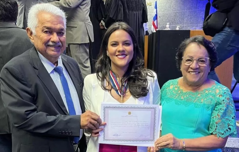 Amanda Waquim ao lado do pai, Sétimo Waquim, e da mãe, Socorro Waquim, durante a cerimônia de posse como juíza substituta no Tribunal Regional Eleitoral do Maranhão, ocupando uma vaga destinada a profissionais da advocacia. Imagem: Reprodução.